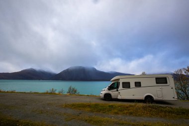 Norveç 'in Lyngen Alpleri' nin sonbahar manzarasında yol kenarına parketmiş bir karavan..