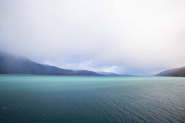 Norveç 'teki Lyngen Alpleri' nin sonbahar manzarası. Karlı zirveleri, dramatik bulutları ve sakin fiyortları var..