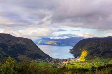 Norveç 'in Vik köyünün üzerinde gün batımı, dağlarla ve fiyortlarla çevrili canlı sonbahar renkleriyle.