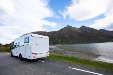 Yağmurlu bir sonbahar gününde Norveç, Bodalen 'de manzaralı bir dağ manzaralı yol kenarına park edilmiş beyaz bir karavan.
