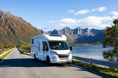 White camper van parked on the side of a road with a scenic mountain view in bodalen, norway, on a rainy autumn day clipart