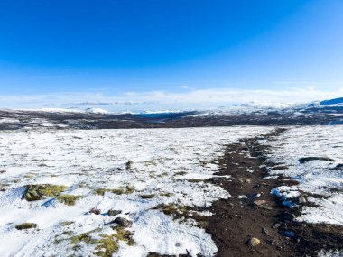 Norveç 'in güneyindeki Dovrefjell Ulusal Parkı' nda sonbahar manzarası, kar ve bitki örtüsüyle çevrili.
