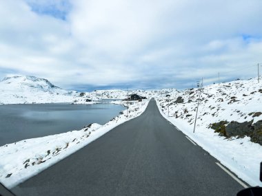 Norveç 'in güneyindeki Sognefjellsvegen yolu boyunca uzanan kış manzarası, karla kaplı dağlar ve geniş, sakin bir arazi içerir..