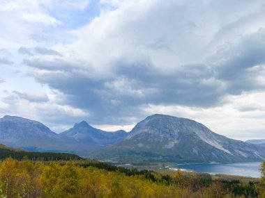 Bulutlu gökyüzünün altındaki saguenay fiyortunun manzarası. Güneş ışınları delip geçiyor ve dramatik bir manzara yaratıyor.