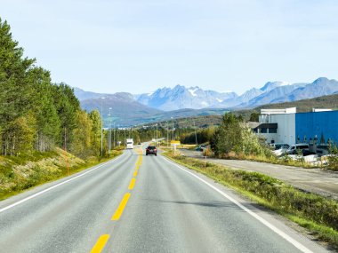 İsveç 'in Kiruna şehrinde sonbahar yeşillikleri ve güzel göl manzaralı bir yolda karavanla yolculuk yapmak..