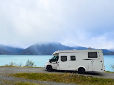 Norveç 'in Lyngen Alpleri' nin sonbahar manzarasında yol kenarına parketmiş bir karavan..