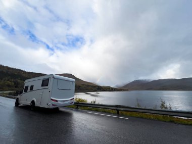 Norveç 'in Senja Adası' nın sonbahar manzarasında, fiyortları ve dağları olan bir karavan..