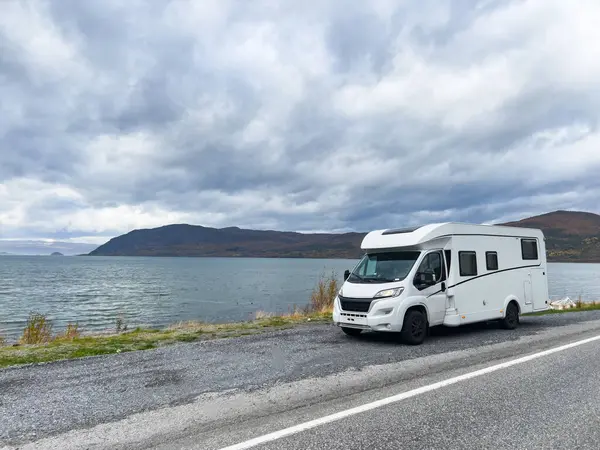 Norveç 'in Lyngen Alpleri' nin sonbahar manzarasında yol kenarına parketmiş bir karavan..