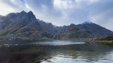 Su dağları ve Norveç 'teki bulutlu gökyüzünü yansıtır.