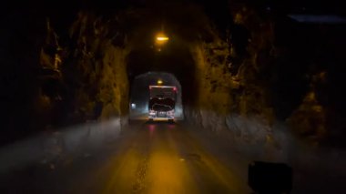 Gece vakti dar bir tünele yaklaşan bir araç Senja, Norveç 'ten çıkıyor.