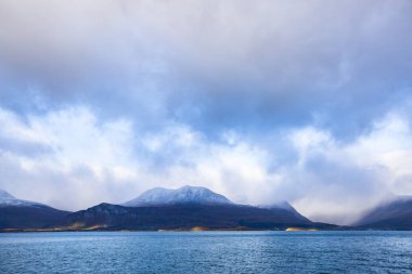 Norveç 'teki Lyngen Alpleri' nin sonbahar manzarası. Karlı zirveleri, dramatik bulutları ve sakin fiyortları var..