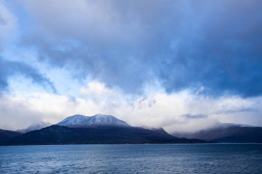 Norveç 'teki Lyngen Alpleri' nin sonbahar manzarası. Karlı zirveleri, dramatik bulutları ve sakin fiyortları var..