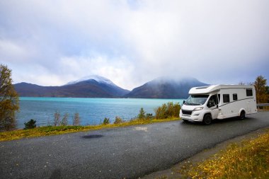 Norveç 'in Lyngen Alpleri' nin sonbahar manzarasında yol kenarına parketmiş bir karavan..