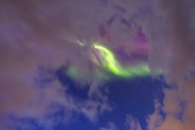 The stunning Northern Lights over Lofoten Islands, northern Norway, with vivid colors lighting up the night sky above mountains. clipart