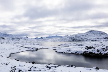 Norveç 'in güneyindeki Sognefjellsvegen yolu boyunca uzanan kış manzarası, karla kaplı dağlar ve geniş, sakin bir arazi içerir..