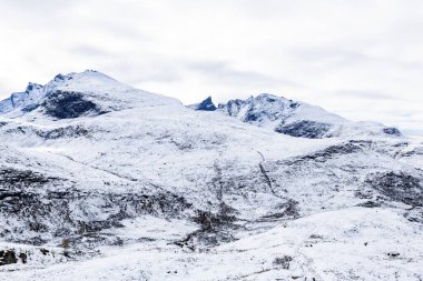 Norveç 'in güneyindeki Sognefjellsvegen yolu boyunca uzanan kış manzarası, karla kaplı dağlar ve geniş, sakin bir arazi içerir..