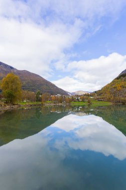 Norveç, Skjolden 'de sonbahar manzarası. Dağları ve renkli yaprakları yansıtan sakin bir göl..