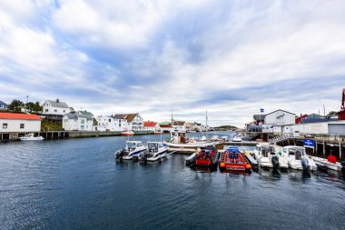 Norveç, Lofoten Adaları 'ndaki Henningsvaer manzarası liman boyunca uzanan ve arka planda dağlar bulunan geleneksel binaları gösteriyor..