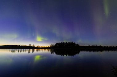 İsveç 'in Kiruna kentindeki kuzey ışıkları Eylül ayında sakin suları yıldızlar ve ormanlarla yansıtıyor..