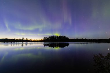 İsveç 'in Kiruna kentindeki kuzey ışıkları Eylül ayında sakin suları yıldızlar ve ormanlarla yansıtıyor..