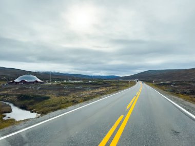 Norveç 'teki dağlık bir arazide bulutlu bir gökyüzünün altında uzanan manzara rotası