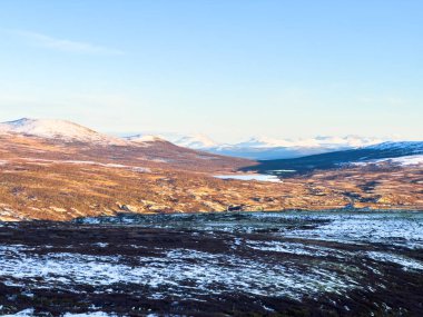 Autumn landscape in Dovrefjell National Park, south Norway, surrounded by snow and vegetation clipart