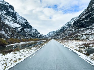 A winter landscape along the Sognefjellsvegen road in south Norway, featuring snow-covered mountains and a vast, serene terrain. clipart