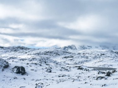 Norveç 'in güneyindeki Sognefjellsvegen yolu boyunca uzanan kış manzarası, karla kaplı dağlar ve geniş, sakin bir arazi içerir..
