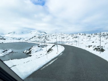 Norveç 'in güneyindeki Sognefjellsvegen yolu boyunca uzanan kış manzarası, karla kaplı dağlar ve geniş, sakin bir arazi içerir..