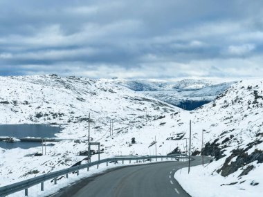 Norveç 'in güneyindeki Sognefjellsvegen yolu boyunca uzanan kış manzarası, karla kaplı dağlar ve geniş, sakin bir arazi içerir..