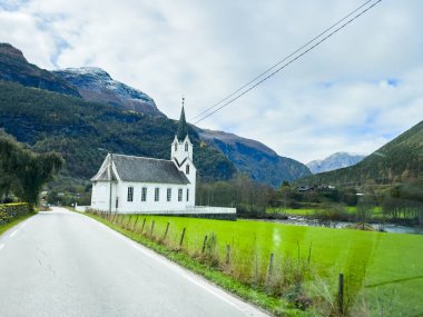 Autumn landscape in Skjolden, Norway, with a calm lake reflecting the mountains and colorful foliage. clipart