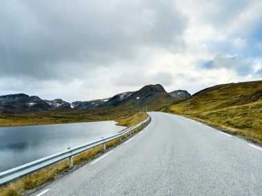 Norveç 'in Vikoyri köyünün üzerinde gün batımı, dağlarla ve fiyortlarla çevrili, canlı sonbahar renkleriyle..