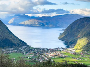Norveç 'in Vikoyri köyünün üzerinde gün batımı, dağlarla ve fiyortlarla çevrili, canlı sonbahar renkleriyle..