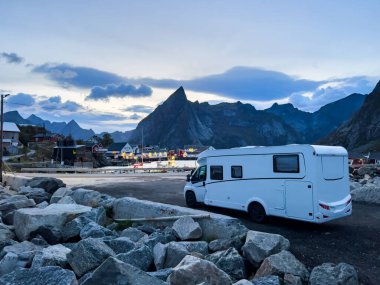 Motorhomes at sunrise with the stunning reflection of mountains and scenic landscape in Reine, Lofoten Islands, northern Norway. clipart