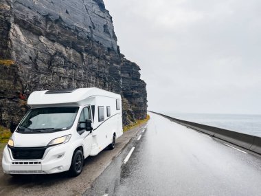 Yağmurlu ve sisli bir günde Nordkapp, Norveç 'e giden e69 yolunda giden beyaz bir karavan.