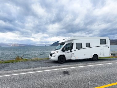 Norveç 'in Lyngen Alpleri' nin sonbahar manzarasında yol kenarına parketmiş bir karavan..