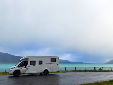 Norveç 'in Lyngen Alpleri' nin sonbahar manzarasında yol kenarına parketmiş bir karavan..