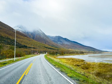 Norveç 'in Senja Adası' nın sonbahar manzarasında, fiyortları ve dağları olan bir karavan..