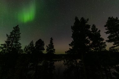 İsveç 'in Kiruna kentindeki kuzey ışıkları Eylül ayında sakin suları yıldızlar ve ormanlarla yansıtıyor..
