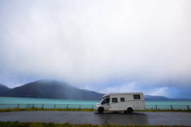 Norveç 'in Lyngen Alpleri' nin sonbahar manzarasında yol kenarına parketmiş bir karavan..