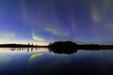 İsveç 'in Kiruna kentindeki kuzey ışıkları Eylül ayında sakin suları yıldızlar ve ormanlarla yansıtıyor..