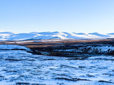 Norveç 'in güneyindeki Dovrefjell Ulusal Parkı' nda sonbahar manzarası, kar ve bitki örtüsüyle çevrili.