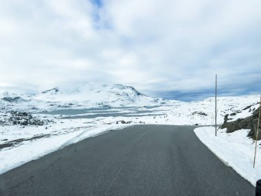 A winter landscape along the Sognefjellsvegen road in south Norway, featuring snow-covered mountains and a vast, serene terrain. clipart