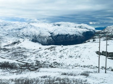 Norveç 'in güneyindeki Sognefjellsvegen yolu boyunca uzanan kış manzarası, karla kaplı dağlar ve geniş, sakin bir arazi içerir..