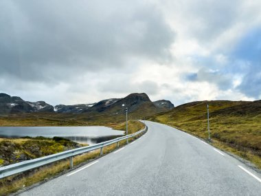 Norveç 'in Vikuyri köyünün üzerinde gün batımı, dağlarla ve fiyortlarla çevrili canlı sonbahar renkleriyle.