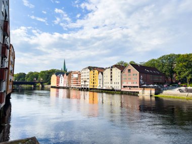 Geleneksel renkli ahşap evler, Norveç, trondheim 'daki Nidelva Nehri' ni kaplıyor. Güneşli bir günde güzel bir yansıma yaratıyor.