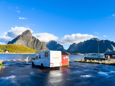 Motorhomes at sunrise with the stunning reflection of mountains and scenic landscape in Reine, Lofoten Islands, northern Norway. clipart