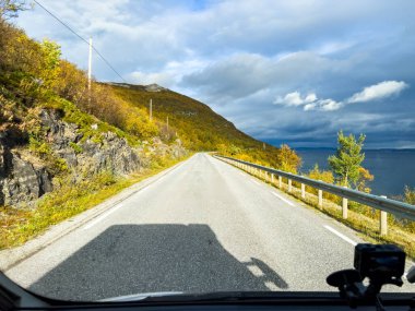 Gösterge paneli, sonbaharda manzaralı kıyı otoyolu boyunca giden aracın görüntüsü