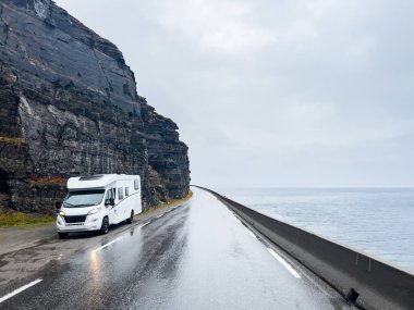 Yağmurlu ve sisli bir günde Nordkapp, Norveç 'e giden e69 yolunda giden beyaz bir karavan.