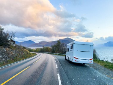 Norveç 'in Lyngen Alpleri' nin sonbahar manzarasında yol kenarına parketmiş bir karavan..